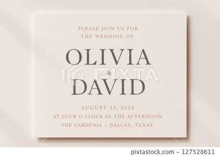 Wedding invitation card with elegant typography on soft neutral background announcing Olivia and David ceremony details 127528611