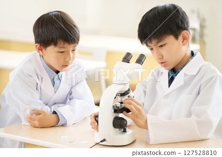 穿白大褂的小學生透過顯微鏡觀察 127528810