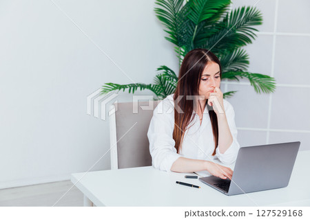 Business woman working on laptop at office desk online 127529168