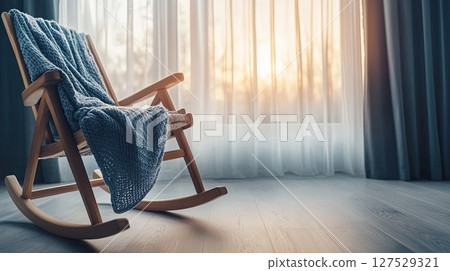 Scandinavian-style cozy corner with handmade knitted blanket and wooden rocking chair 127529321