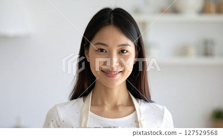 廚房裡繫著圍裙微笑的年輕女子 廚房裡繫著圍裙微笑的年輕女子 127529568