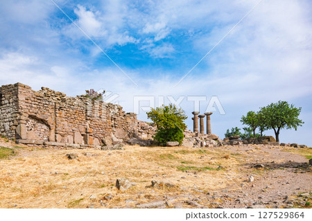 Temple of Athena ruins in Assos Turkey with ancient stone wall and distant Doric columns among trees 127529864