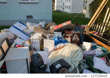 A lot of waste in a city near the haus. Big garbage with old wood furniture, toys, boxes, plastic bags on a street and green grass in spring sunny trash dump day in Germany. A lot of waste in a city near the haus. Big garbage with old wood furniture, toys, boxes, plastic bags on a street and green grass in spring sunny trash dump day in Germany. 127529916