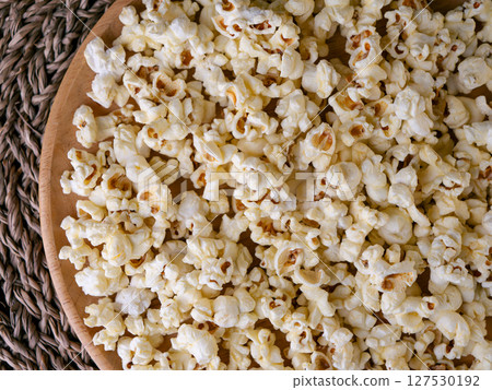 Butter salted popcorn on wooden table. 127530192