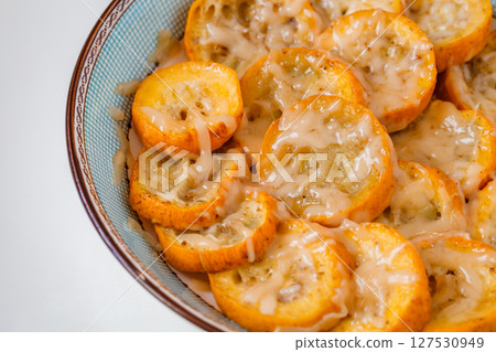 Yellow zucchini baked with grated cheese in bowl, selective focus  127530949