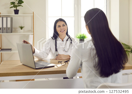 Smiling female doctor giving advice to female patient Smiling female doctor giving advice to female patient 127532495