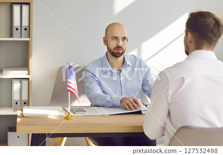 USA consul talking to young man about his problems with immigration and visa application 127532498