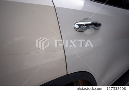 Damaged car door with visible scratch near handle 127532608