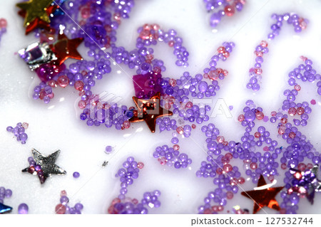 Close up of confetti tinsel glitter and shining stars on white background Close up of confetti tinsel glitter and shining stars on white background 127532744