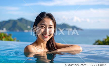 A woman with a cute smile relaxing at the pool 127533084