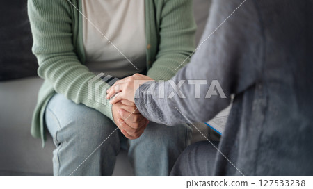 Psychologist, friend or family holding hands to encourage patient with depression, anxiety, therapy 127533238