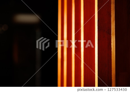 Warm light cascading through wooden slats creates a cozy atmosphere in an intimate setting Warm light cascading through wooden slats creates a cozy atmosphere in an intimate setting 127533430