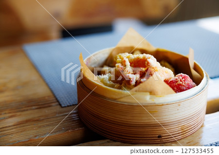 Scrumptious dim sum served in bamboo steamer showcasing the warmth of authentic Chinese cuisine 127533455
