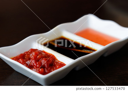 Explore the vibrant flavors of Chinese cuisine with unique dipping sauces arranged artfully in a small dish Explore the vibrant flavors of Chinese cuisine with unique dipping sauces arranged artfully in a small dish 127533470