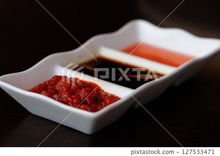 Savoring the flavors of Chinese cuisine with vibrant sauces in a stylish dish 127533471