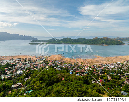 Drone view of Coastal City. Coron Town Proper. Blue sky and clouds. Palawan, Philippines. Drone view of Coastal City. Coron Town Proper. Blue sky and clouds. Palawan, Philippines. 127533984