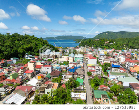 Buildings and houses in coastal town with ferry in port. Romblon Island, Romblon, Philippines. 127533985