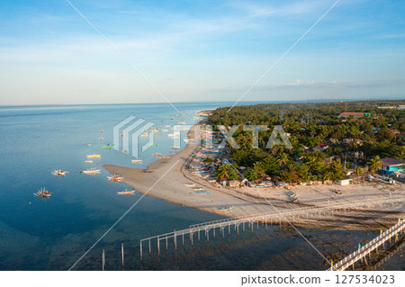 Fishing boats and baywalk in Bantayan Island, Madridejos, Cebu. Tropical landscape with sunset reflection. Philippines. 127534023