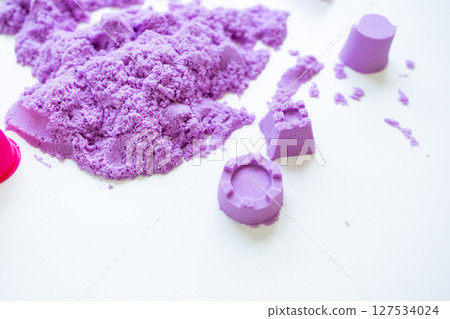 Purple kinetic sand with molded shapes on white surface Purple kinetic sand with molded shapes on white surface 127534024