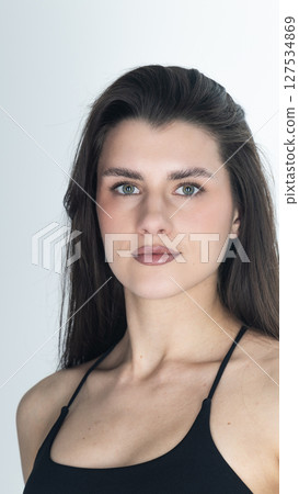 Portrait of confident young woman with long dark hair and brown eyes Portrait of confident young woman with long dark hair and brown eyes 127534869