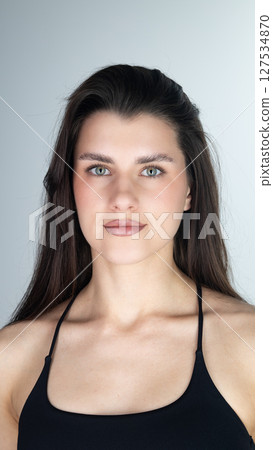 Portrait of confident young woman with long dark hair and brown eyes Portrait of confident young woman with long dark hair and brown eyes 127534870