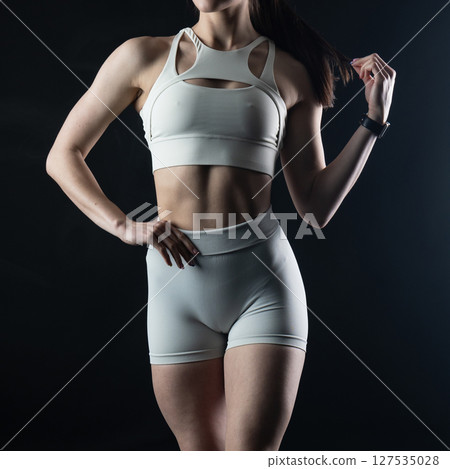 athletic female body on dark background, fitness woman, athletic girl torso 127535028
