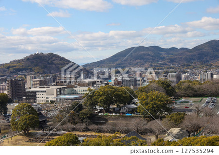 Kumamoto, Japan - January 25, 2023: Landscape of Kumamoto city from Kumamoto castle. Kumamoto is the capital city in Kyushu, Japan. Kumamoto, Japan - January 25, 2023: Landscape of Kumamoto city from Kumamoto castle. Kumamoto is the capital city in Kyushu, Japan. 127535294