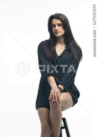 Young woman sitting on stool wearing transparent heels and smartwatch Young woman sitting on stool wearing transparent heels and smartwatch 127535354