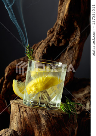 Cocktail gin and tonic with lemon slices and sprig of rosemary. 127535511