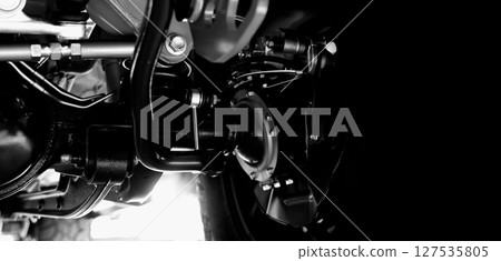 Car suspension part. Close up of a rear car suspension and exhaust system. such as coil springs link arms axle housing and performance exhaust. For auto engineering or car suspension part industry use 127535805