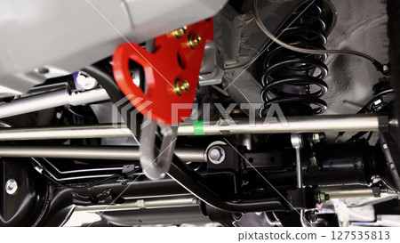 Car suspension part. Close up of a rear car suspension and exhaust system. such as coil springs link arms axle housing and performance exhaust. For auto engineering or car suspension part industry use Car suspension part. Close up of a rear car suspension and exhaust system. such as coil springs link arms axle housing and performance exhaust. For auto engineering or car suspension part industry use 127535813
