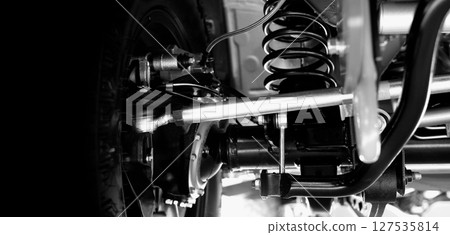 Car suspension part. Close up of a rear car suspension and exhaust system. such as coil springs link arms axle housing and performance exhaust. For auto engineering or car suspension part industry use 127535814