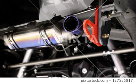 Car suspension part. Close up of a rear car suspension and exhaust system. such as coil springs link arms axle housing and performance exhaust. For auto engineering or car suspension part industry use 127535817
