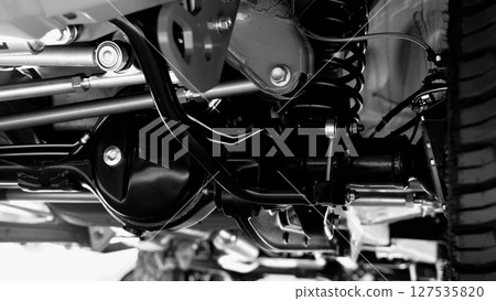 Car suspension part. Close up of a rear car suspension and exhaust system. such as coil springs link arms axle housing and performance exhaust. For auto engineering or car suspension part industry use Car suspension part. Close up of a rear car suspension and exhaust system. such as coil springs link arms axle housing and performance exhaust. For auto engineering or car suspension part industry use 127535820