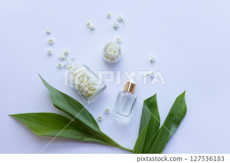 Glass bottle of lily of the valley essential oil with fresh flowers Glass bottle of lily of the valley essential oil with fresh flowers 127536183