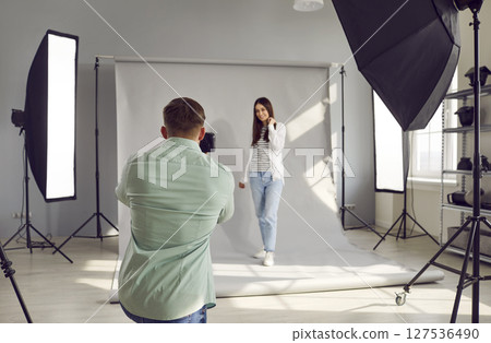 Photographer and model working in modern studio with professional photographic equipment Photographer and model working in modern studio with professional photographic equipment 127536490