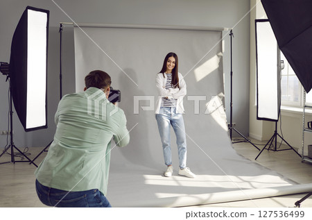 Male photographer shooting model in studio with softboxes Male photographer shooting model in studio with softboxes 127536499