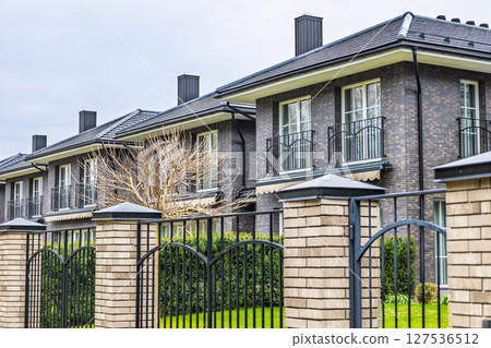 Elegant Modern Townhouses with Brick Facades and Iron Fences in Residential Area 127536512
