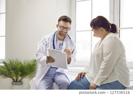 Female fat patient visiting a doctor at the medical office during medical examination. 127536516