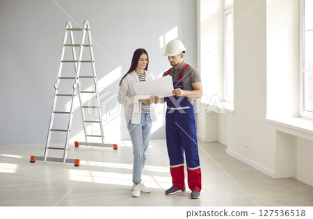 Foreman and home owner discussing house design construction plan 127536518