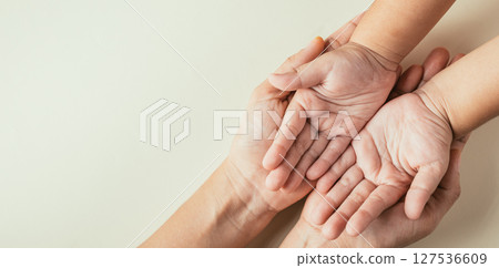 Family Day concept, Top view of parents and kid holding empty hands isolated. Signifying togetherness support and the legacy passed through generations. Family Day concept, Top view of parents and kid holding empty hands isolated. Signifying togetherness support and the legacy passed through generations. 127536609
