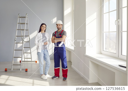 Builder repairman and woman apartment owner discussing future apartment design Builder repairman and woman apartment owner discussing future apartment design 127536615