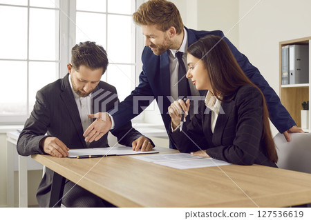 Corporate confident business people having a meeting in office, signing a contract. Corporate confident business people having a meeting in office, signing a contract. 127536619