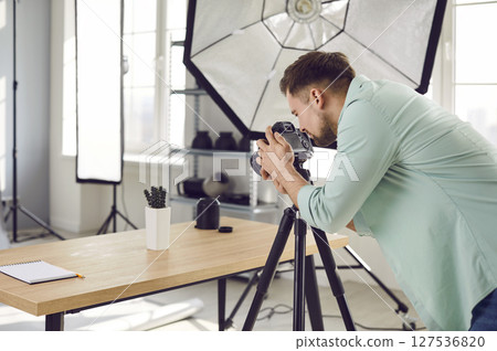 Professional object photographer working in his studio and taking photos of cactus on table Professional object photographer working in his studio and taking photos of cactus on table 127536820