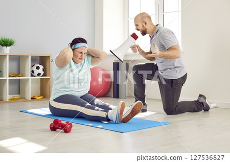 Fat woman shaking press and doing sport exercises with support from a male nurse with megaphone Fat woman shaking press and doing sport exercises with support from a male nurse with megaphone 127536827