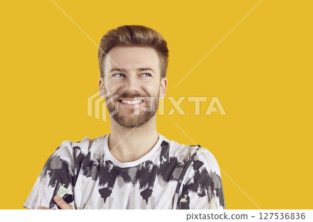 Portrait of smiling bearded man looking to the side on studio yellow background. Portrait of smiling bearded man looking to the side on studio yellow background. 127536836