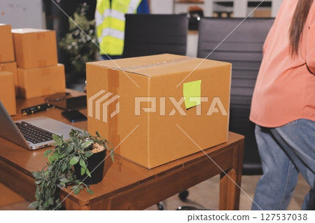 Startup SME small business entrepreneur of freelance Asian woman wearing apron using laptop and box to receive and review orders online to prepare to pack sell to customers, online sme business ideas. 127537038