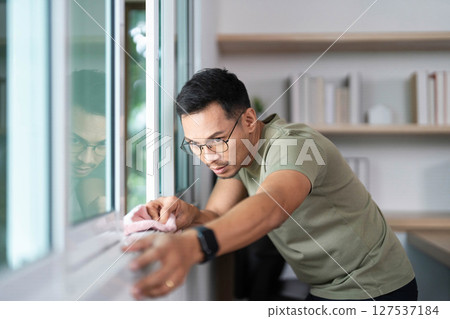 Window Cleaning by a Focused Man. Maintaining a tidy workspace. Window Cleaning by a Focused Man. Maintaining a tidy workspace. 127537184