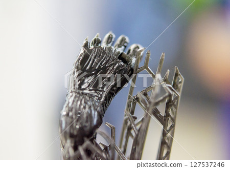 An object printed on a 3D printer from hardened rubber close-up. Model black color created on a 3D printer from hardened rubber under influence of ultraviolet light. SLA 3D printing. Stereolithography 127537246