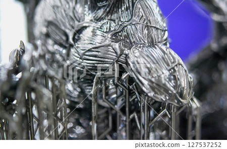 An object printed on a 3D printer from hardened rubber close-up. Model black color created on a 3D printer from hardened rubber under influence of ultraviolet light. SLA 3D printing. Stereolithography 127537252